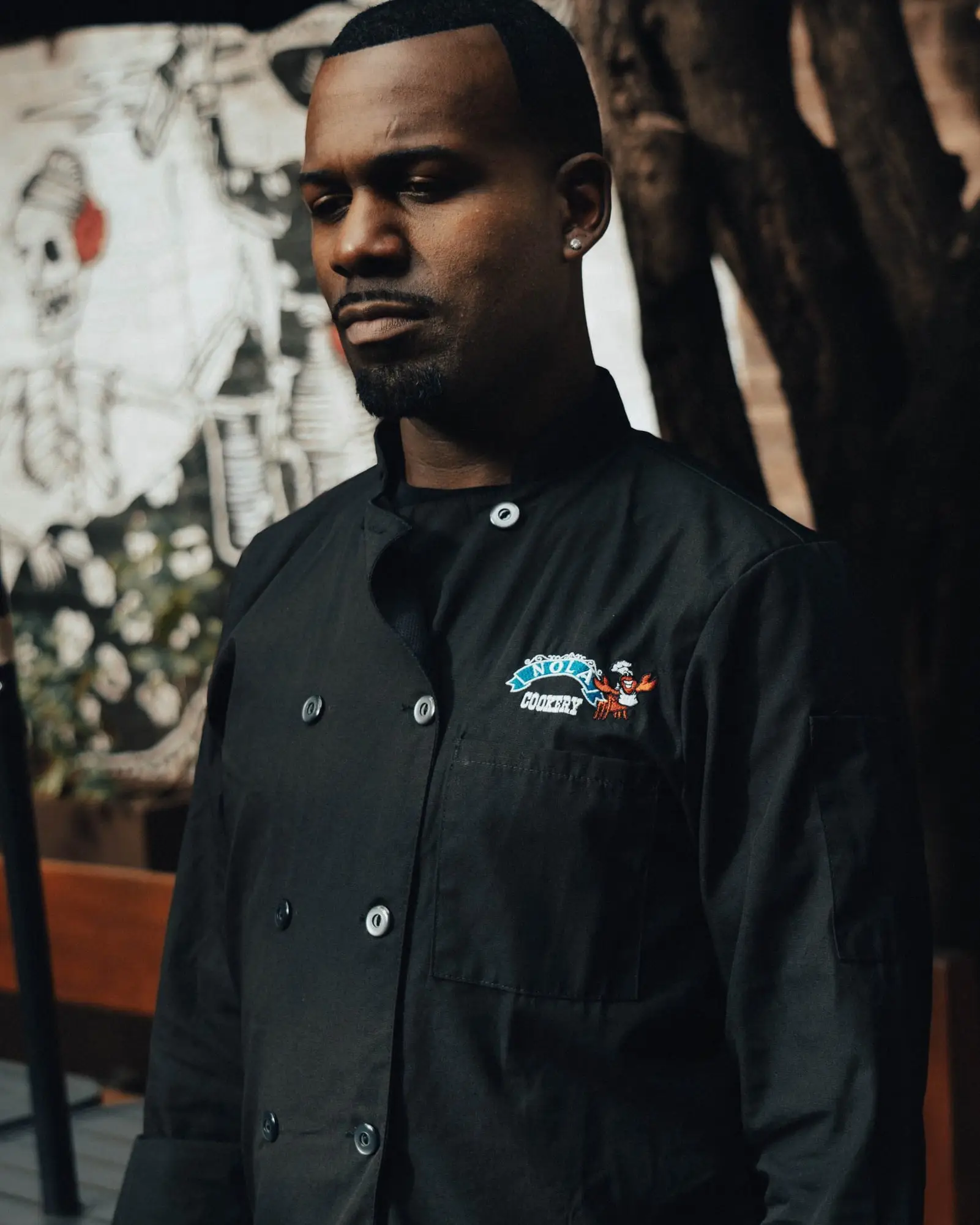 A man wearing the black Oceana chef jacket with the logo