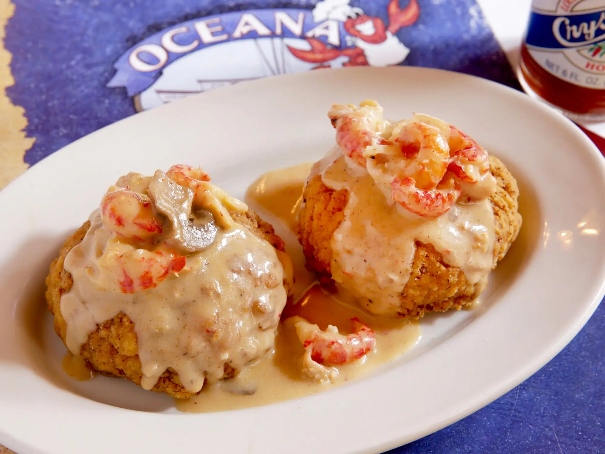 Two Louisiana crabmeat cakes topped with crawfish mushroom cream sauce