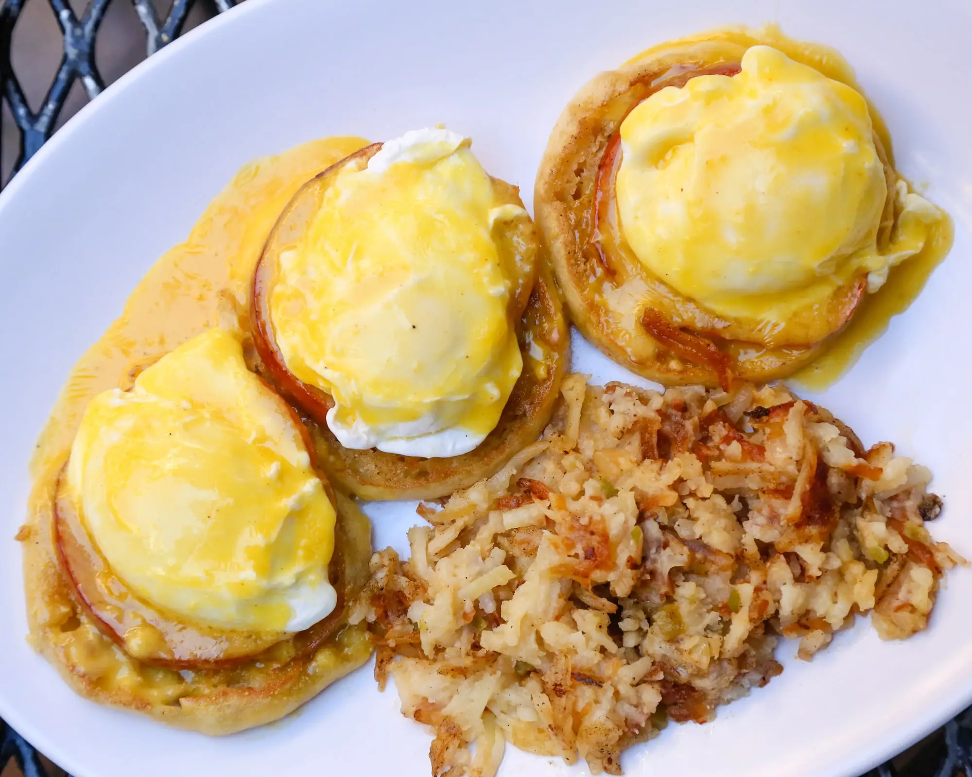 Eggs Benedict on English muffins with hollandaise and crispy hash browns