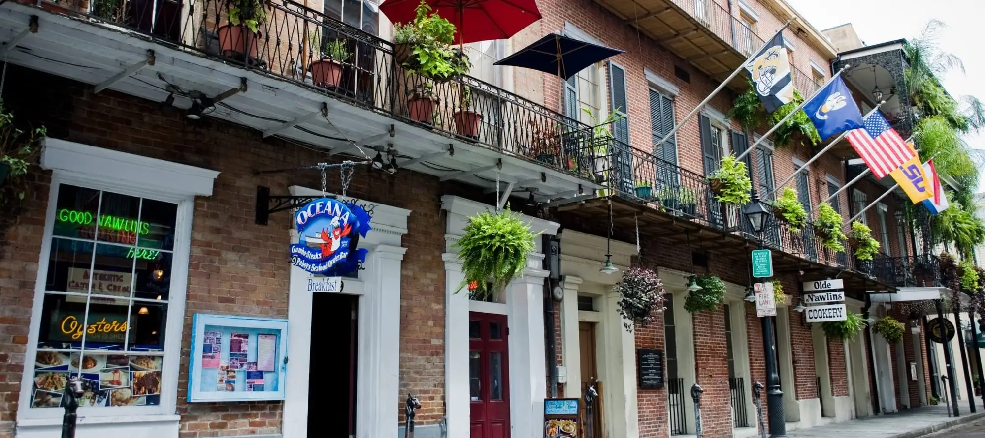 Oceana Grill on Conti Street: a brick French Quarter building with iron balconies, hanging ferns and the Oceana sign over the door