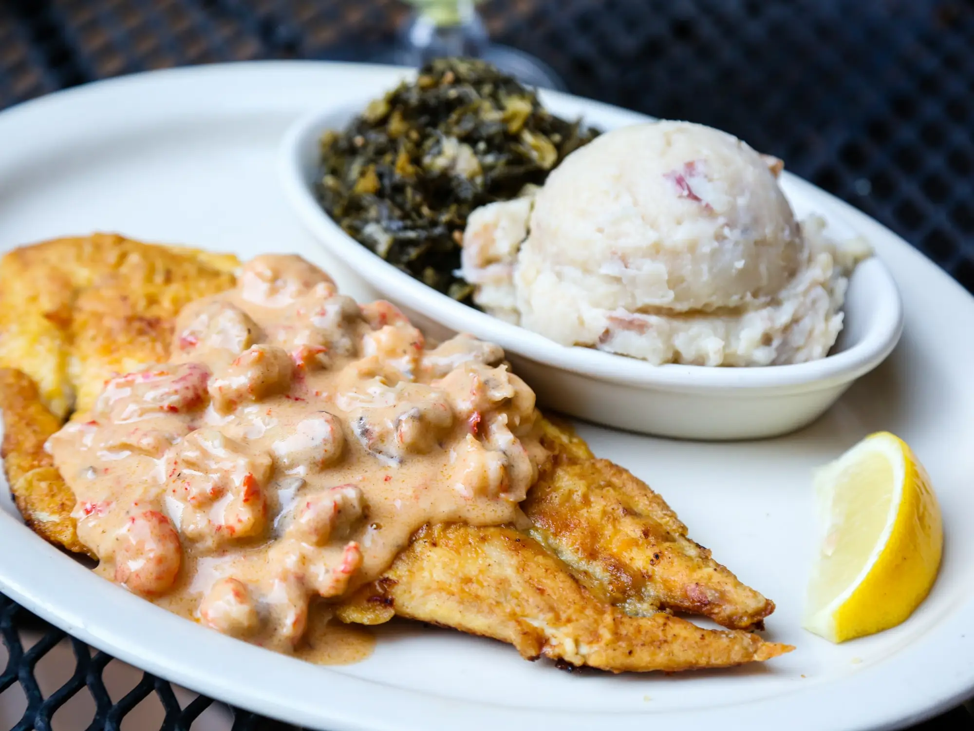 Redfish Oceana: pan-sautéed redfish under crawfish mushroom cream sauce, with garlic mashed potatoes and greens
